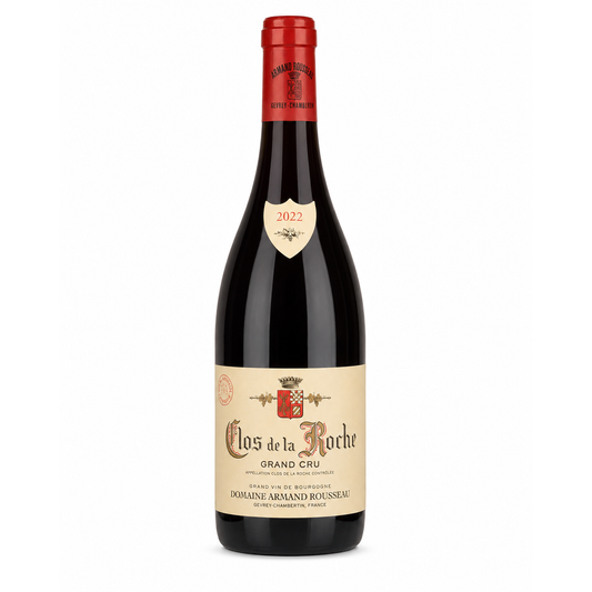 A bottle of Clos de la Roche Grand Cru red wine from Dourine Armand Rousseau, featuring a dark glass bottle, a red foil capsule, and a beige label with a cream shield badge showing the year 2022.