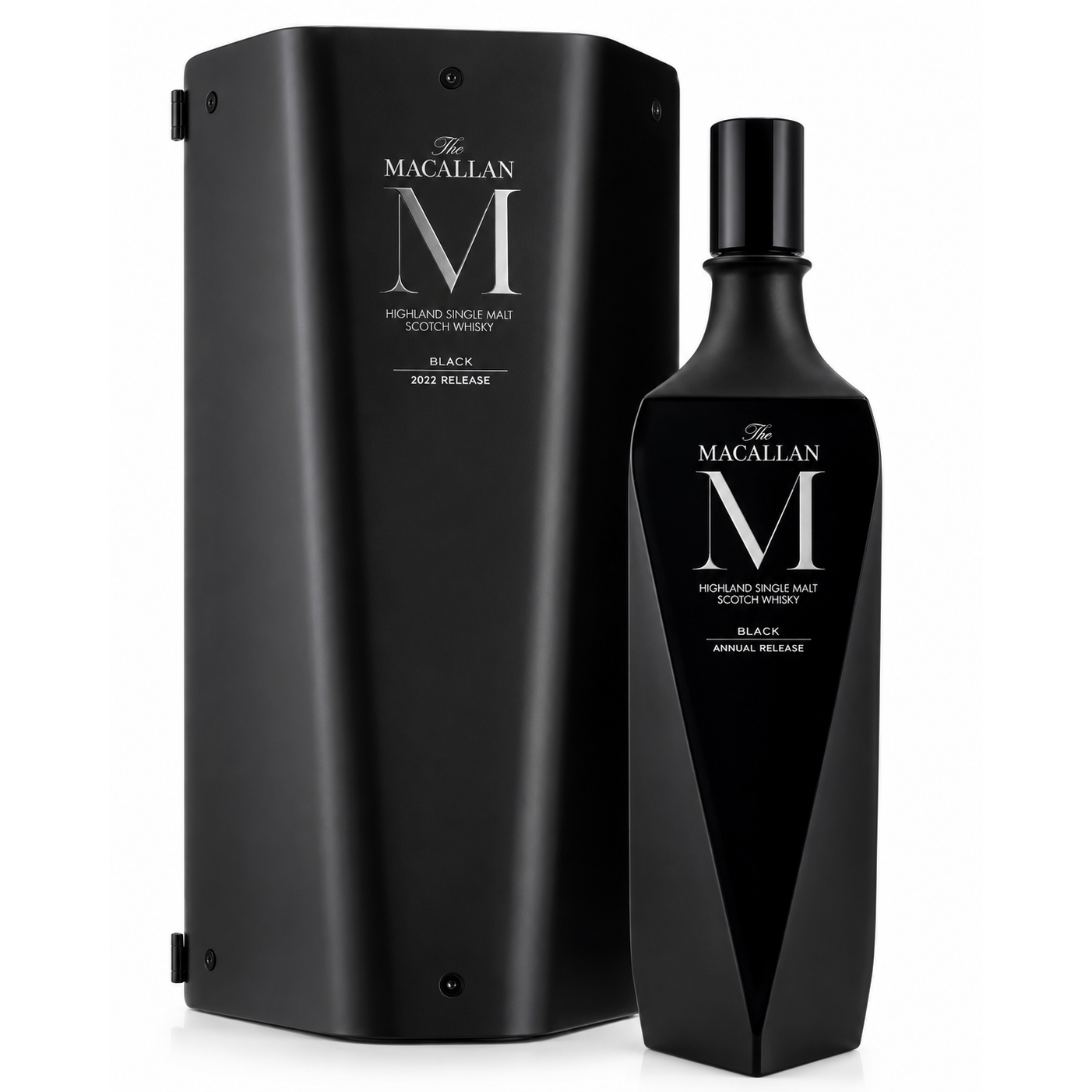 The Macallan M Black Annual Release Scotch whisky bottle next to its matching black presentation box, featuring a large silver 'M' logo and white text on a clean white background.