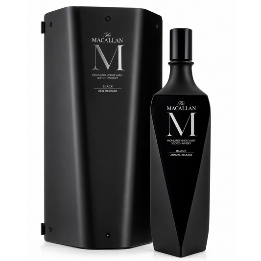 The Macallan M Black Annual Release Scotch whisky bottle next to its matching black presentation box, featuring a large silver 'M' logo and white text on a clean white background.